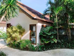 een klein huis met palmbomen ervoor bij Happy Together By Kresna Hospitality in Seminyak