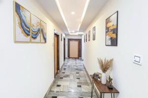 a hallway with a table and paintings on the walls at FabHotel New Shanti in Allahābād