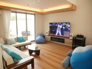 un soggiorno con TV a schermo piatto e divano di 富津 Fun Base a Futtsu