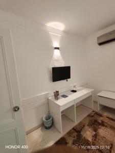 a white living room with a tv on a wall at Elixir Two Bed Rooms in Hurghada