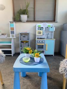a toy kitchen with a blue table with flowers on it at Casa de sueños Benasha con piscina, zona infantil y parking privado in Deltebre