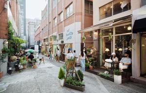 a group of people walking down a city street at 207stay korea in Busan