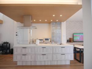 una cucina con mobili bianchi e un lavandino di 富津 Fun Base a Futtsu