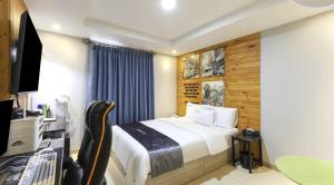 a bedroom with a bed and a desk and a television at Jukdo market G1mini in Pohang