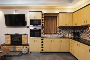 a kitchen with wooden cabinets and a tv on the wall at Pelion Horizon in Zagora