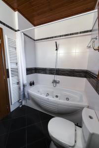 a white bathroom with a tub and a toilet at Pelion Horizon in Zagora +29 photos