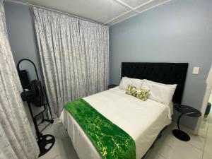 a bedroom with a bed with white sheets and gold pillows at 719 Casuarina, Woodgrange on Sea,Hibberdene in Hibberdene