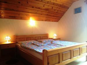 a bedroom with a wooden bed with two lamps on both sides at Farm Stay Juvanija in Solčava