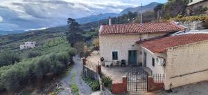 a house on a hill with mountains in the background at IRENE'S village home in Loutrákion