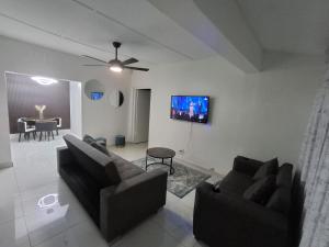 a living room with two couches and a flat screen tv at 719 Casuarina, Woodgrange on Sea,Hibberdene in Hibberdene