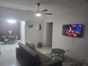 a living room with a couch and a tv on a wall at 719 Casuarina, Woodgrange on Sea,Hibberdene in Hibberdene +3 photos