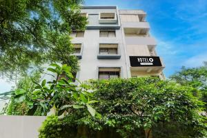 a tall white building with a sign on it at Hotel O Wardha Road Near Airport in Nagpur +23 photos