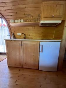 eine Küche mit weißem Kühlschrank und Holzschränken in der Unterkunft Roulotte avec spa privé in Villé + 11 Fotos