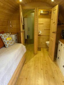 ein Schlafzimmer mit einem Bett und ein Badezimmer mit einer Toilette in der Unterkunft Roulotte avec spa privé in Villé