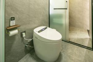 a toilet in a bathroom with a phone on the wall at Lijiang Hengchang Baoyin Mohuakai Inn in Lijiang