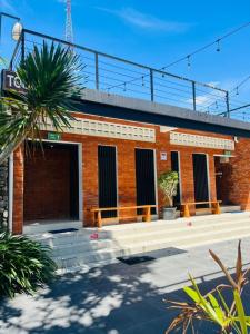 a brick building with two benches in front of it at Ndalem Prabu Sarangan in Sarangan