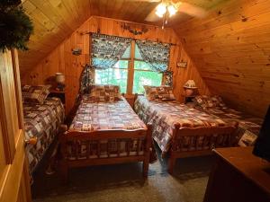 een kamer met 2 bedden in een blokhut bij Camp Quityerbellyachin in Greenville