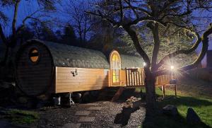 Neben einem Baum steht ein großes Haus. in der Unterkunft Roulotte avec spa privé in Villé