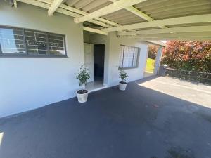 two potted plants sitting on a patio of a house at 719 Casuarina, Woodgrange on Sea,Hibberdene in Hibberdene
