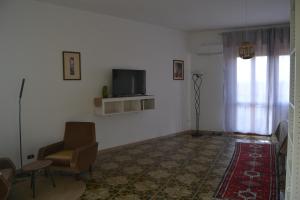 a living room with a tv and a chair at The Domus in Olmedo