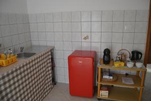 a small kitchen with a red refrigerator and a sink at The Domus in Olmedo +4 photos