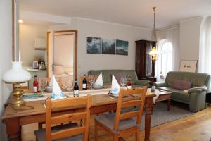 a living room with a table with chairs and a couch at Oberdeck Steuerbord in Greetsiel