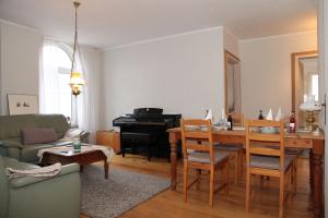 a living room with a table and a piano at Oberdeck Steuerbord in Greetsiel +22 photos