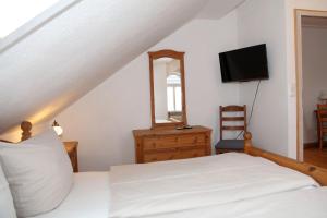 a bedroom with a bed and a mirror and a television at Oberdeck Steuerbord in Greetsiel