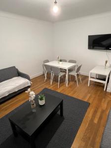 a living room with a couch and a table at Le Toit des Volcans - 8 couchages - Terrasse privée et Wifi in Clermont-Ferrand +3 photos