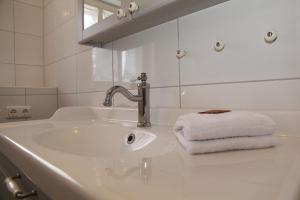 a bathroom sink with a faucet and a towel at Oberdeck Steuerbord in Greetsiel