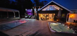 a house with a swimming pool at night at Privat Spirit Spa Villa in Vallentuna