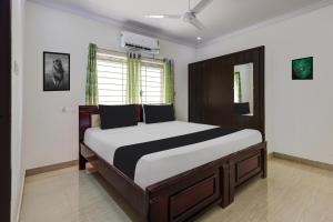 a bedroom with a large bed in a room at Super Hotel O Ramaraopet Near Kakinada Beach in Kākināda