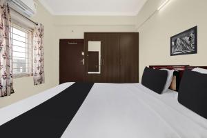 a bedroom with a large bed with black and white sheets at Super Hotel O Ramaraopet Near Kakinada Beach in Kākināda +24 photos