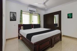 a bedroom with a large bed in a room at Super Hotel O Ramaraopet Near Kakinada Beach in Kākināda