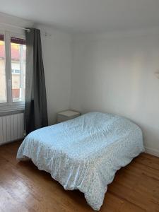 a bedroom with a bed with a blue blanket at Le Toit des Volcans - 8 couchages - Terrasse privée et Wifi in Clermont-Ferrand