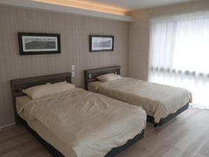 due letti in una camera da letto con finestra di 富津 Fun Base a Futtsu