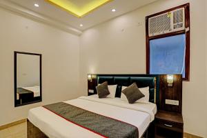 a bedroom with a bed with a mirror and a window at Super Collection O Sector 55 Noida Near Noida Stadium in Noida
