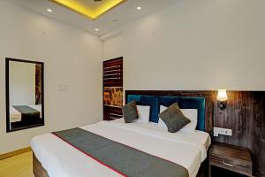 a bedroom with a large white bed with blue pillows at Super Collection O Sector 55 Noida Near Noida Stadium in Noida