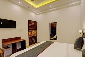 a bedroom with a bed and a tv on the wall at Super Collection O Sector 55 Noida Near Noida Stadium in Noida +22 photos