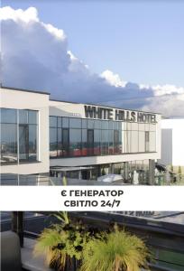 a white building with a sign that reads white hits hotel at WHITE HILLS HOTEL spa&sport in Uzhhorod