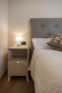 Bett mit Nachttisch mit Lampe in der Unterkunft Portal Fosc Suites in Peñíscola