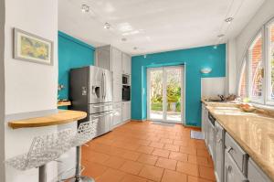 eine Küche mit blauen Wänden und weißen Schränken in der Unterkunft Au bonheur des vacances in Verdun-sur-Garonne