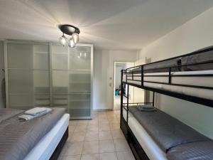 ビューラータールにあるFamilienapartment Buehlertal bei Buehl Baden Baden und Schwarzwaldの二段ベッド2台とウォークインクローゼットのある部屋