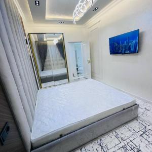 een bed in een kamer met een spiegel bij Rent room 999 in Samarkand