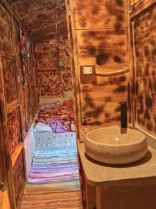 Siwa Gardenia Cottage اكواخ سيوة جاردينيا في سيوة: حمام مع حوض في كابينة خشبية