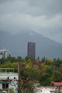 un grand bâtiment au sommet d'une colline plantée d'arbres dans l'établissement Balkan Hostel, à Tirana