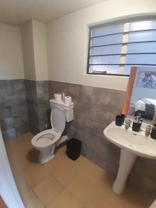 a bathroom with a toilet and a sink at Mountain Vue in Hartbeespoort