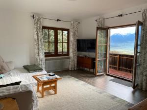 a living room with a bed and a large window at Weberhof in Samerberg