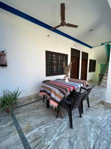 a dining room with a table and a ceiling fan at Tiny Spot Hostel Rishikesh in Rishīkesh