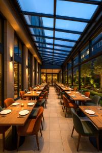 a restaurant with wooden tables and chairs and windows at Ramada by Wyndham Arnavutkoy in Istanbul